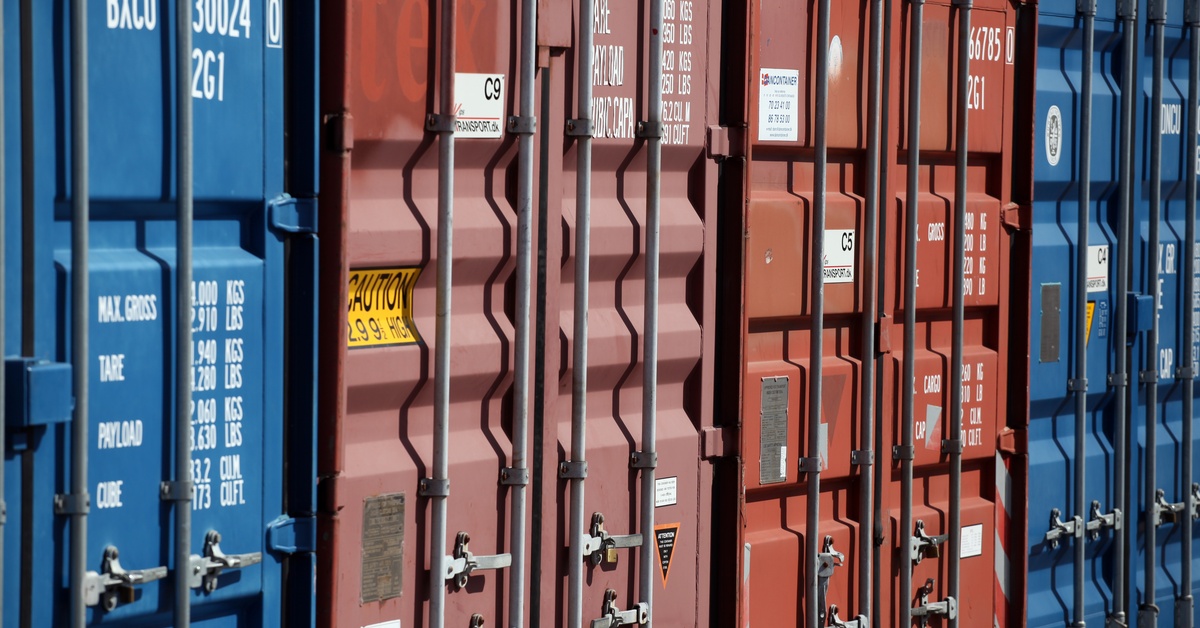 Four colorful storage containers in a row, each with different locking mechanisms on the front of them.