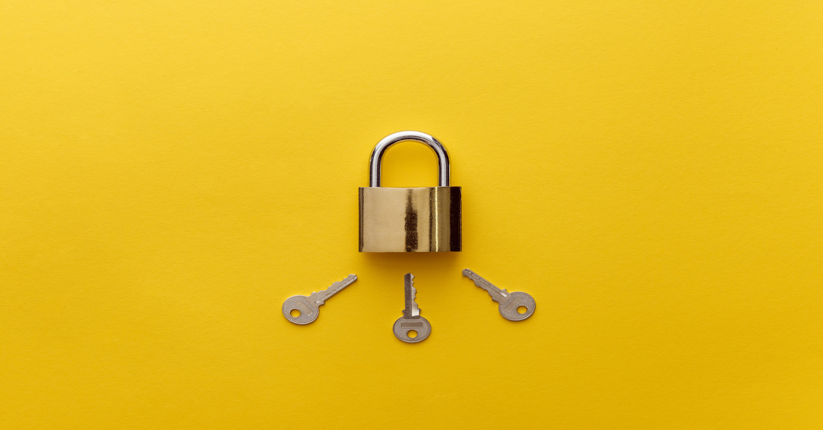 A brass padlock with three silver keys arranged below it on a bright yellow background, creating a simple, clean layout.